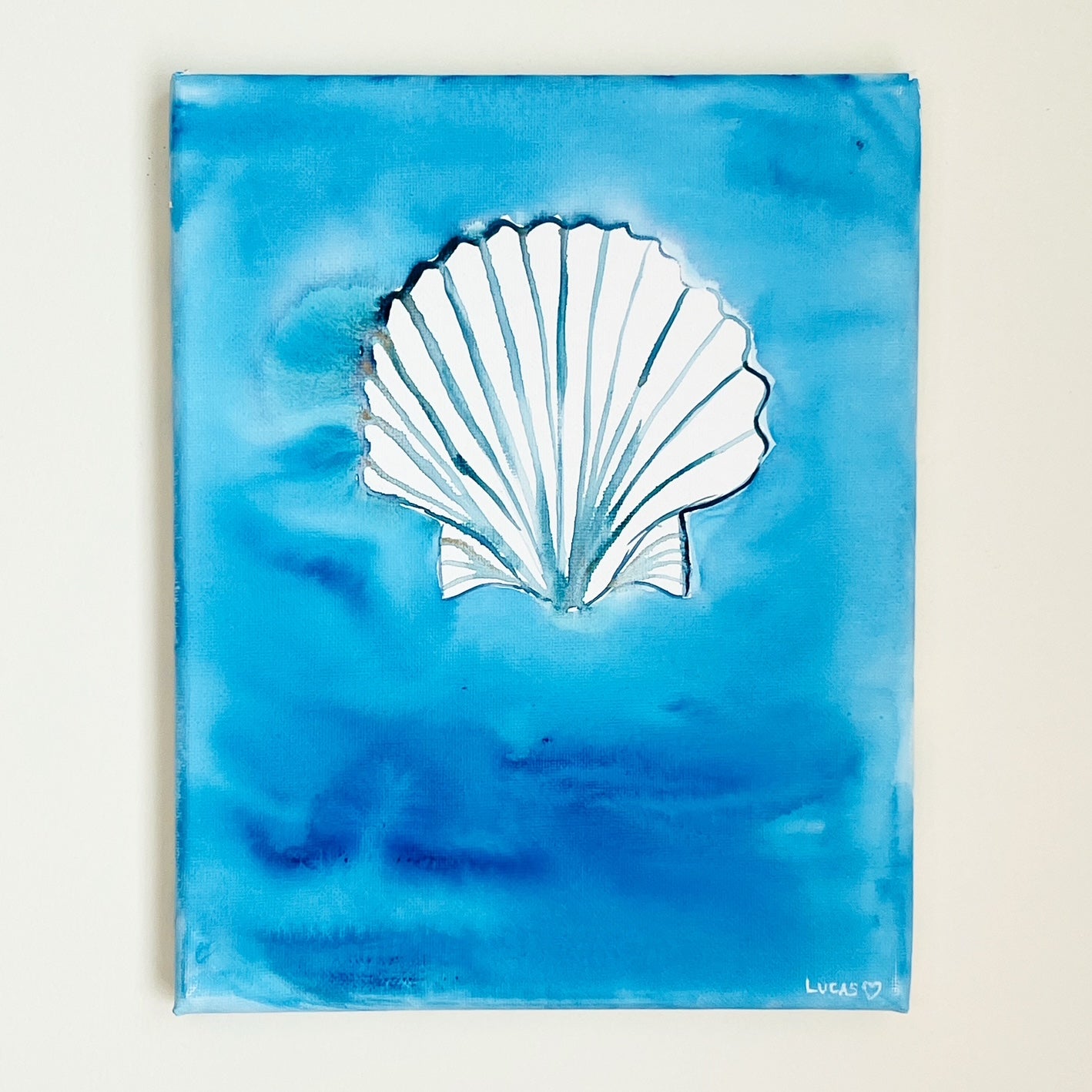 Watercolor seashell painted on canvas with layered ocean blues, coastal art by Ashley Lucas